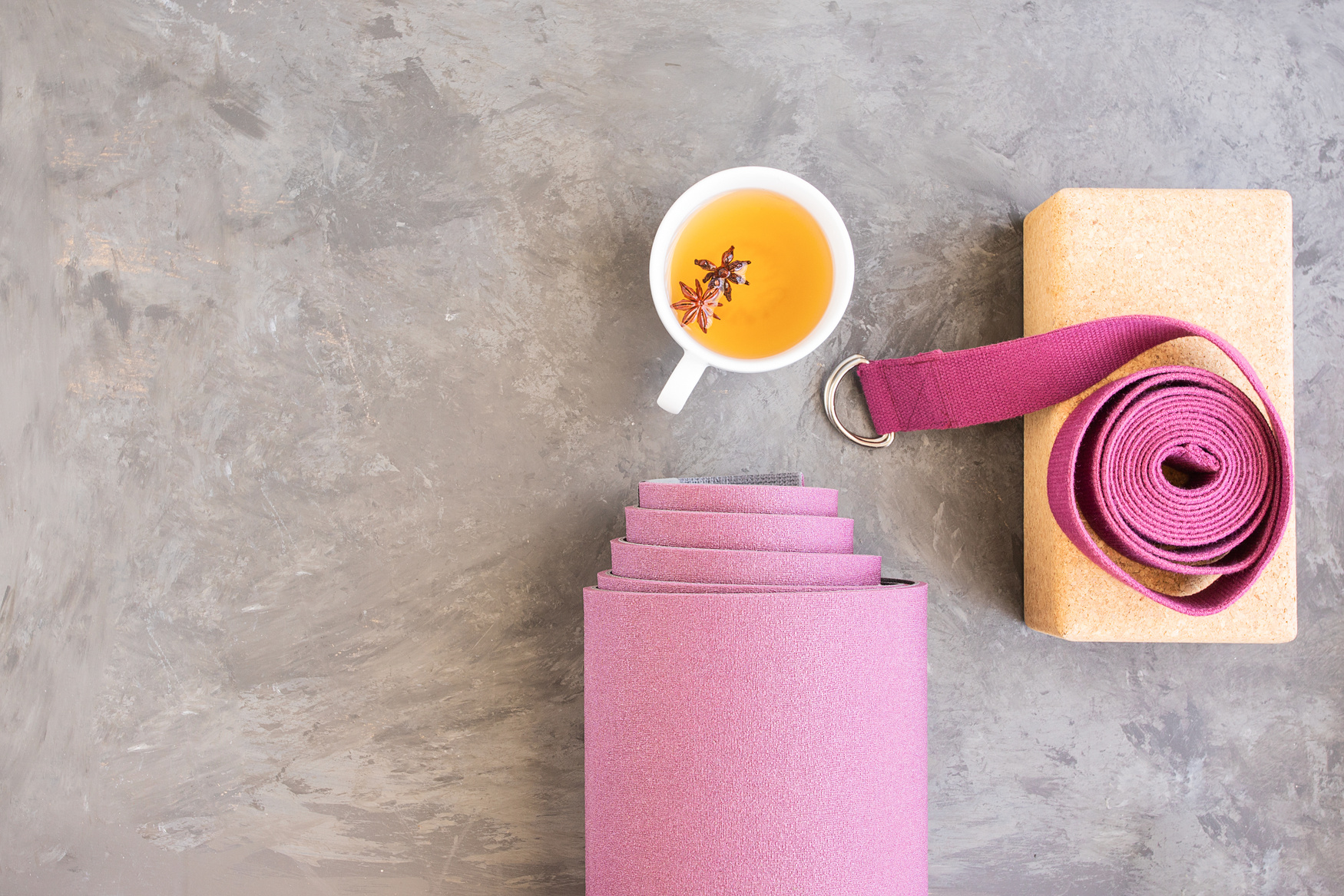 Rolled yoga mat, cork block, yoga strap, mala beads and Ayurveda tea for relax yoga practice y meditation.